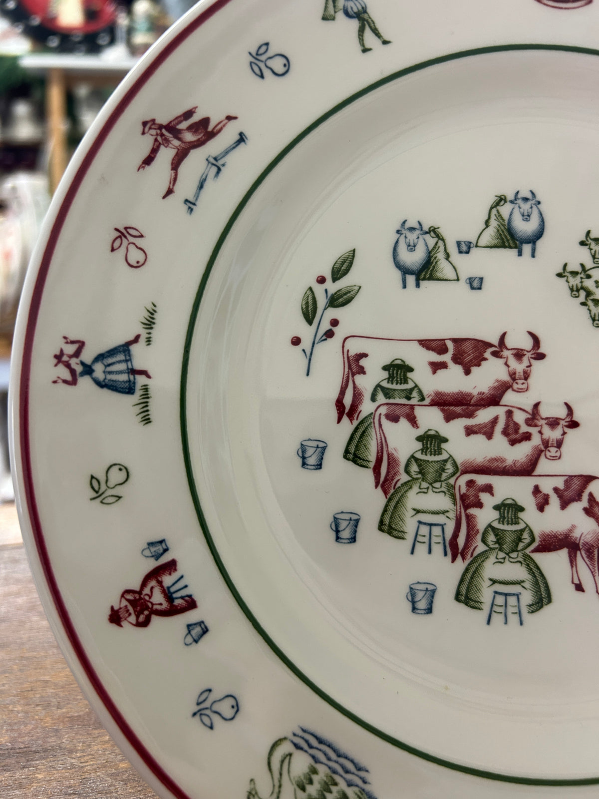 Decorative Christmas plate close-up of multicolor farm animals and green wreath leaves