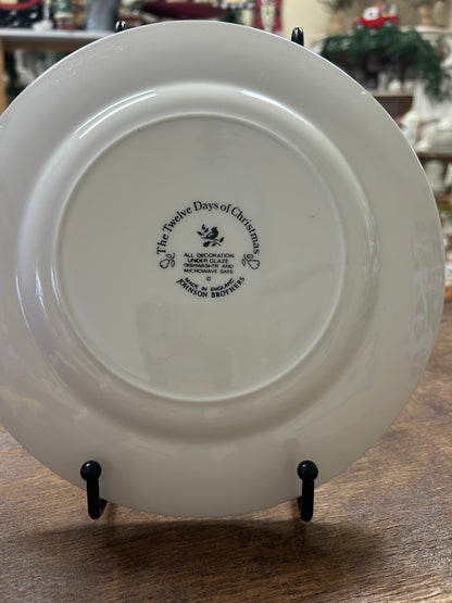White decorative plate back with stamped maker text and date, on black stands