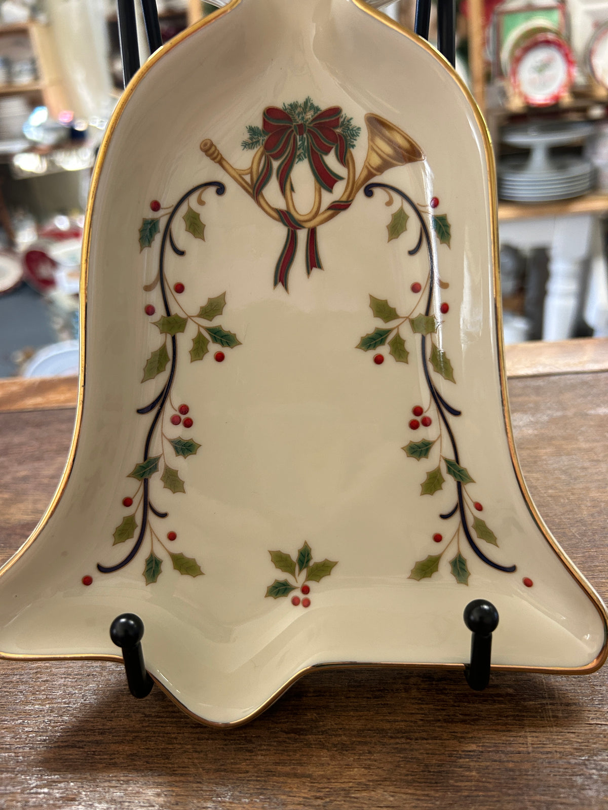 Cream bell-shaped serving bowl with gold trim and holiday holly and bow pattern