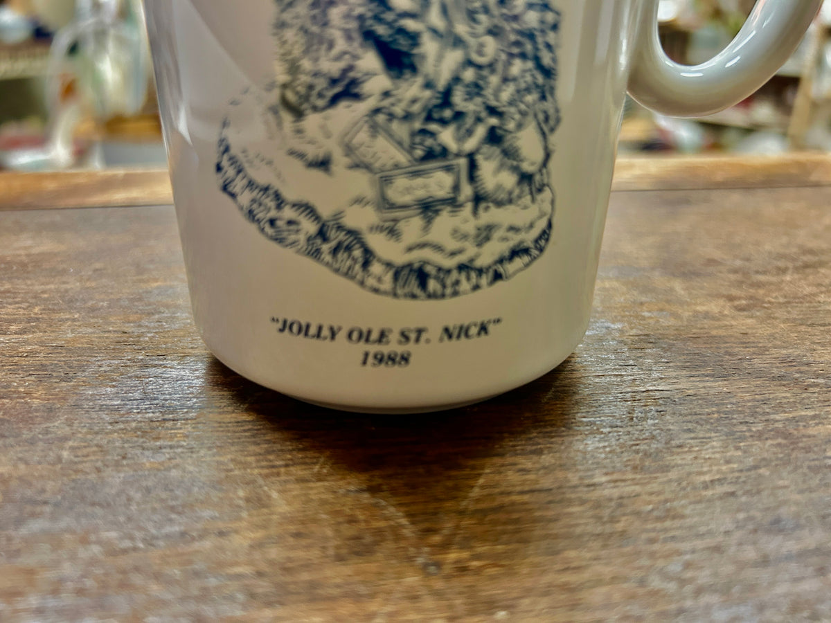 White mug close-up of blue 'JOLLY OLE ST. NICK' and 1988 date text