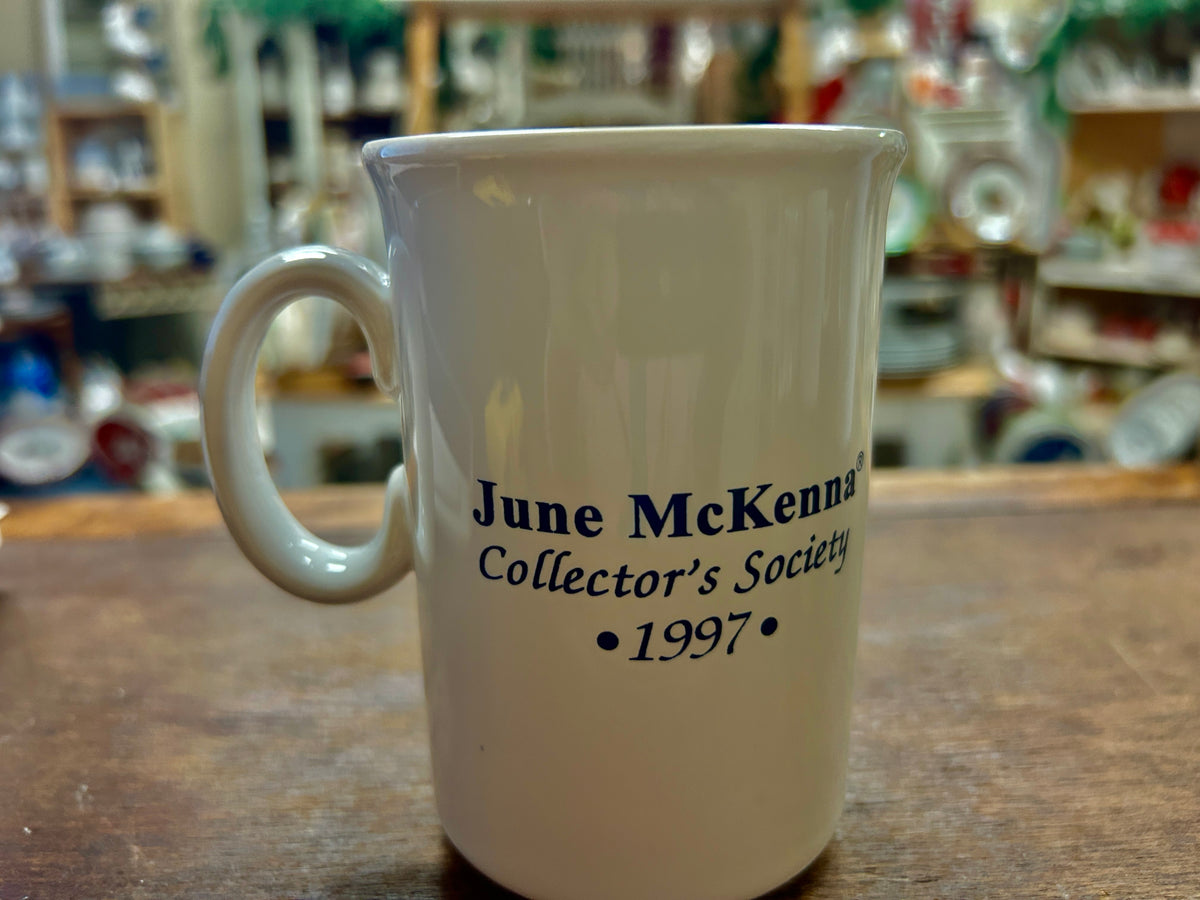 Ceramic mug with blue text “June McKenna Collector’s Society” and “1997”