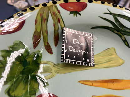 Vegetable bowl interior close-up with Droli Designs label and painted carrot and greens