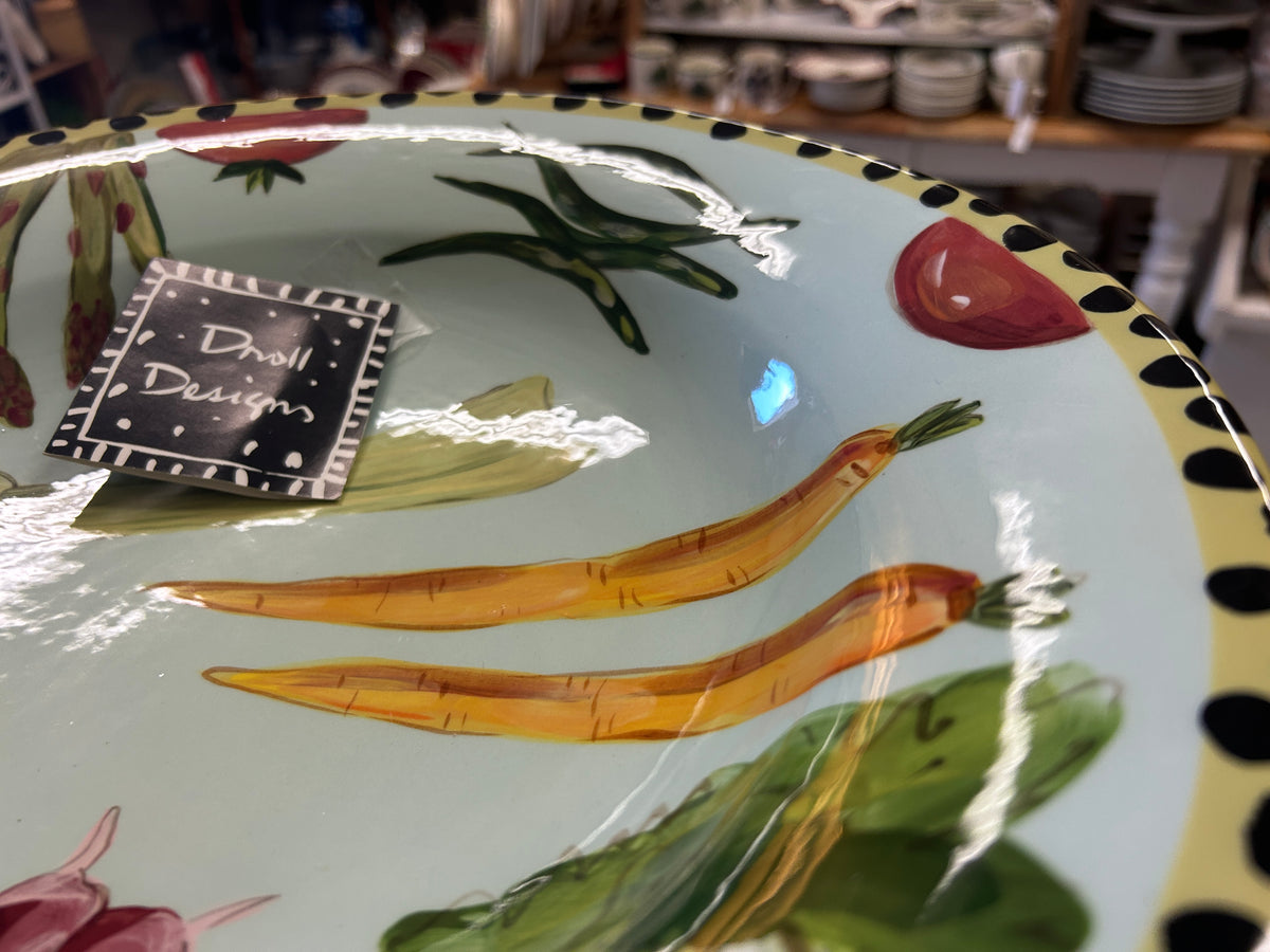 Vegetable bowl close-up with painted vegetables and black-and-yellow dotted rim