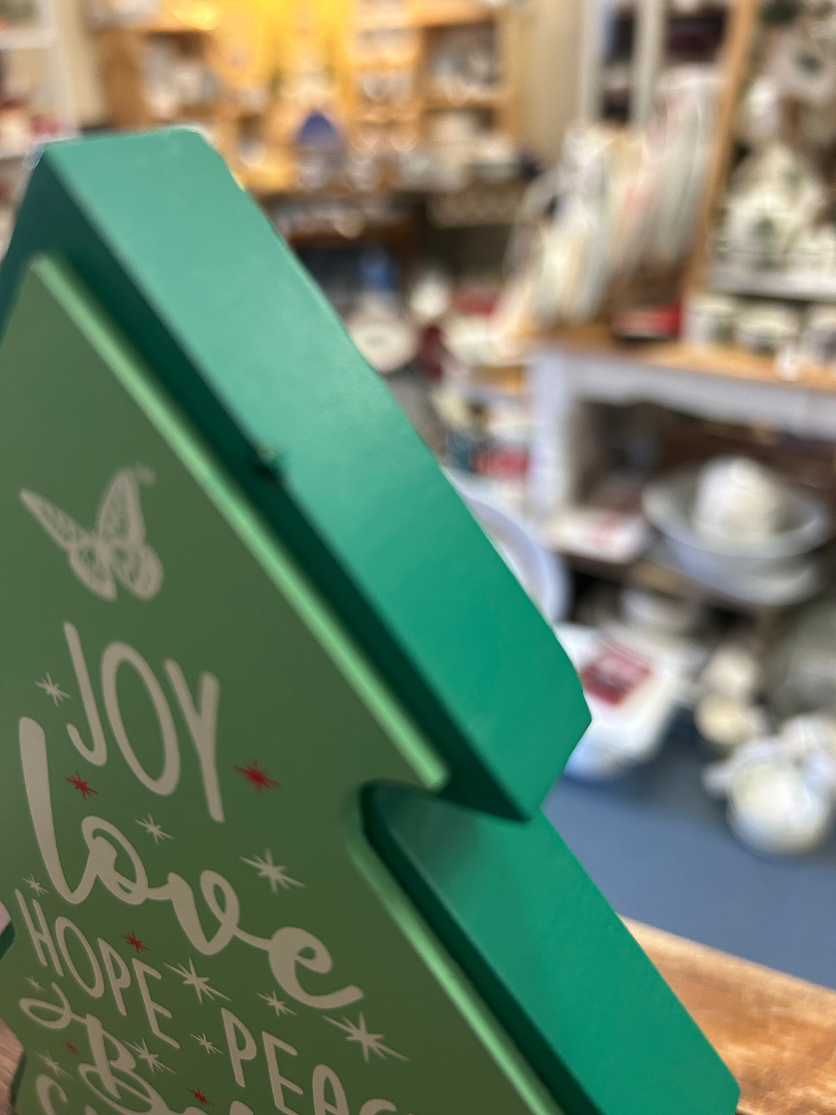 Green wooden Christmas tree side with 'Joy Love Hope Peace' lettering and butterfly