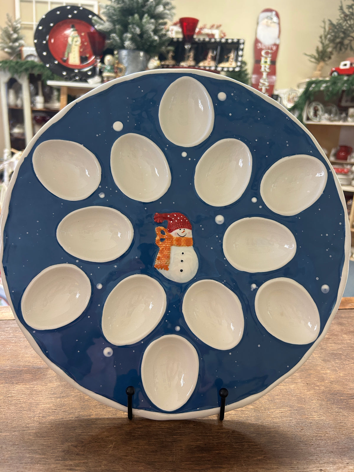 Blue ceramic deviled egg tray with snowman, starry dots, and 12 white egg cups