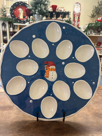 Blue ceramic deviled egg tray with snowman, starry dots, and 12 white egg cups
