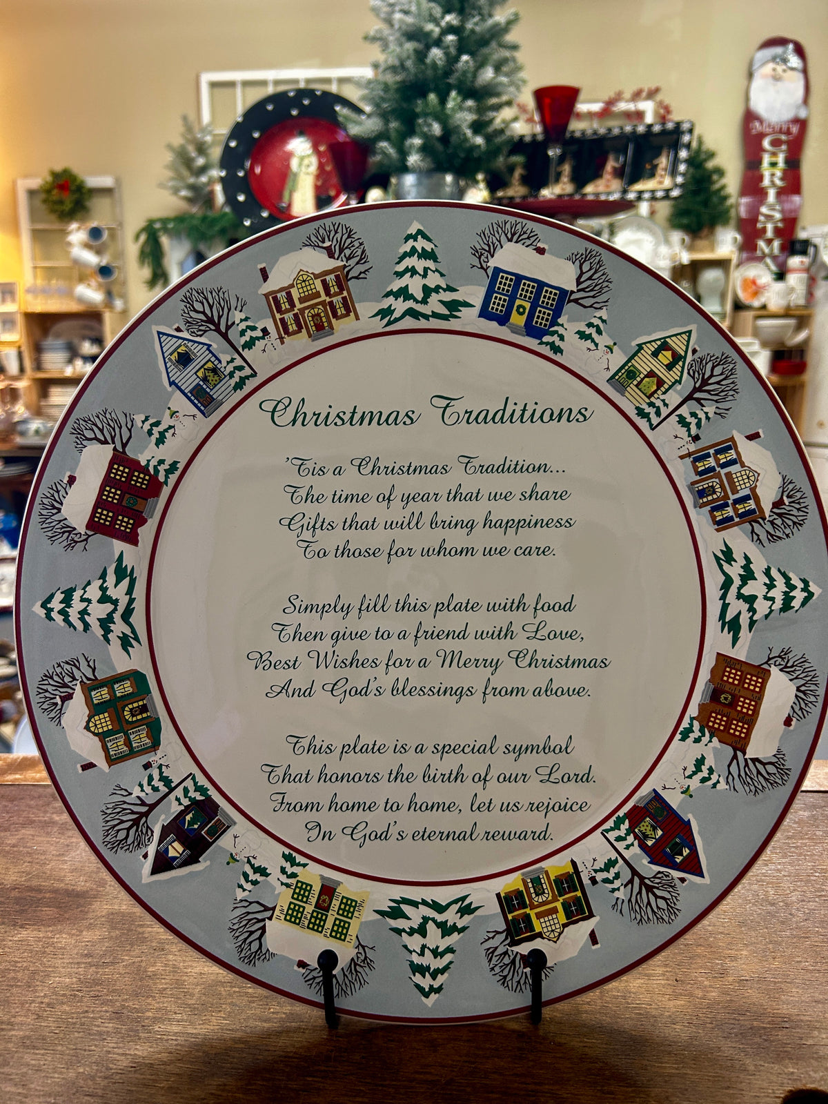 Round Christmas traditions decorative platter with red rim, houses and trees, script center