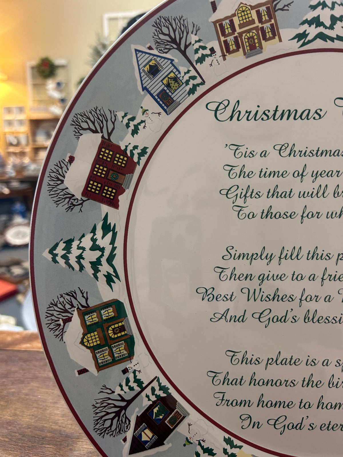 Round decorative Christmas platter close-up of script text and multicolor houses on rim