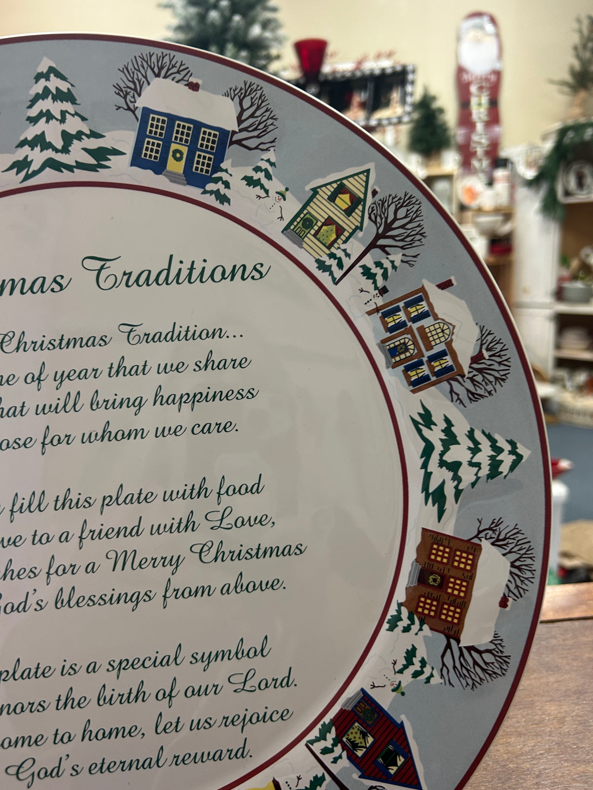 Round Christmas traditions platter angled view with multicolor houses and trees, red rim