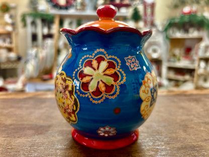 Ceramic sugar bowl with blue glaze, red lid knob, central floral medallion Dutch wax design
