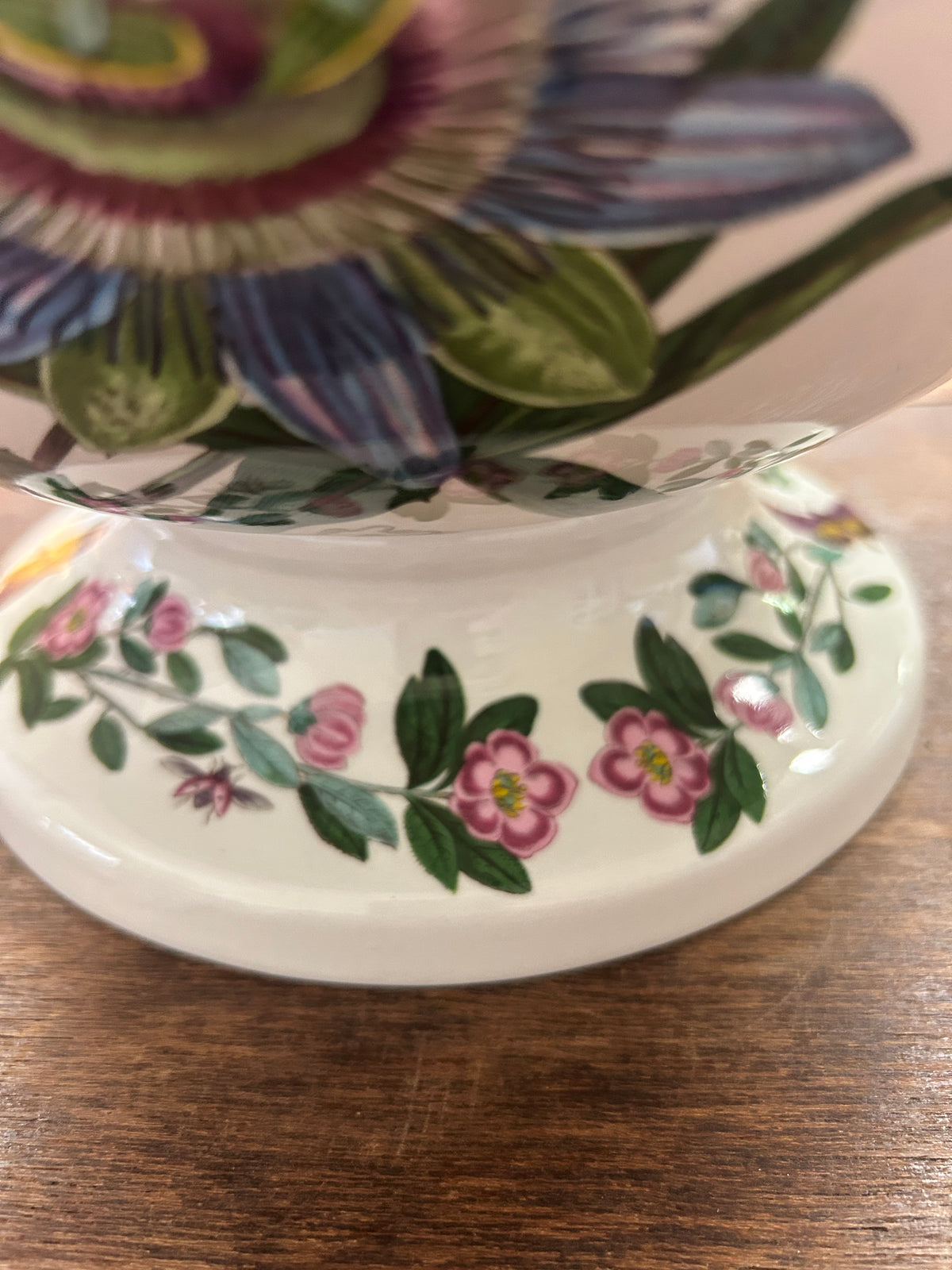 Ceramic tureen lid with green and pink floral sprig pattern on white surface