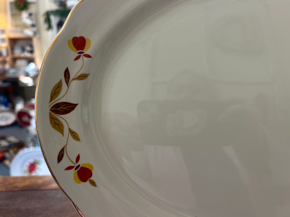 White oval platter with multicolor leaf-and-branch decoration along the side