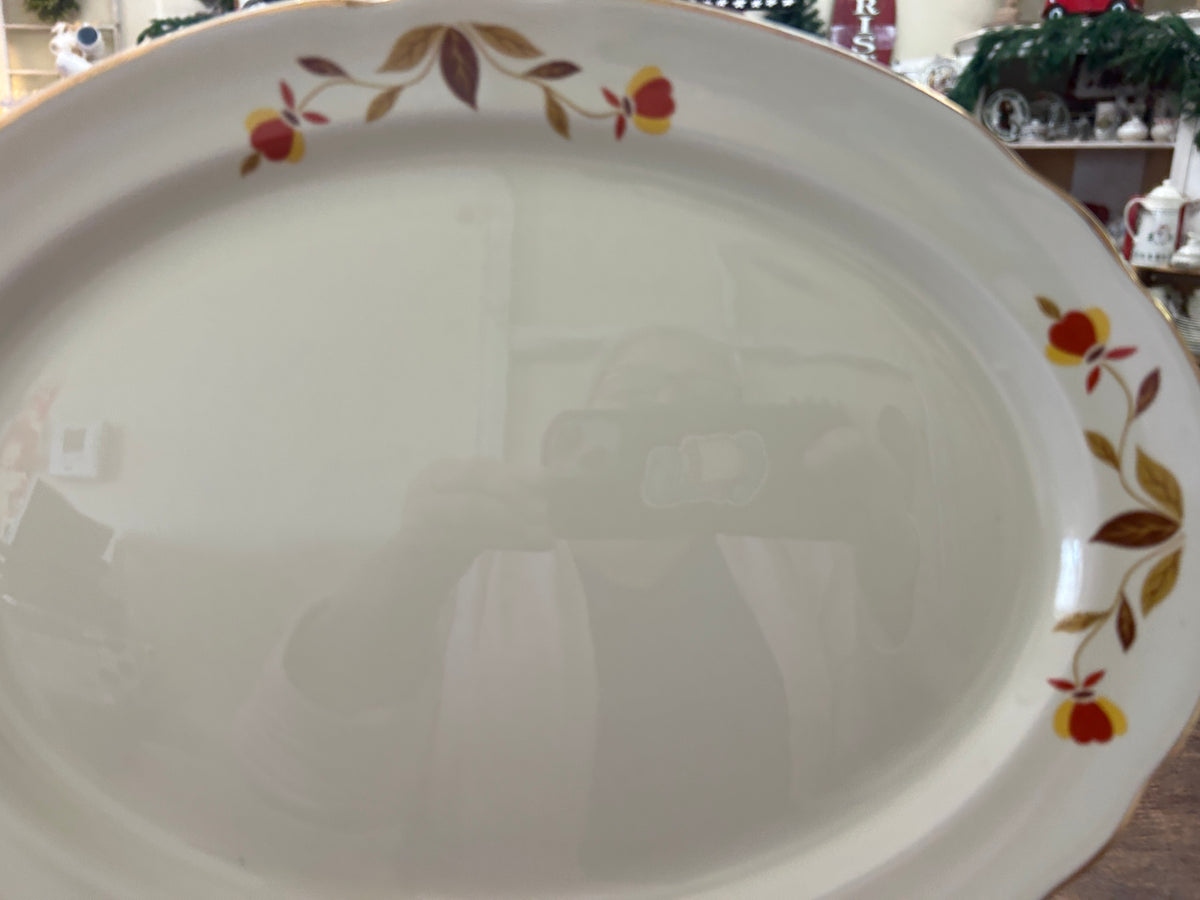 White oval serving dish with multicolor leaf rim and glossy interior