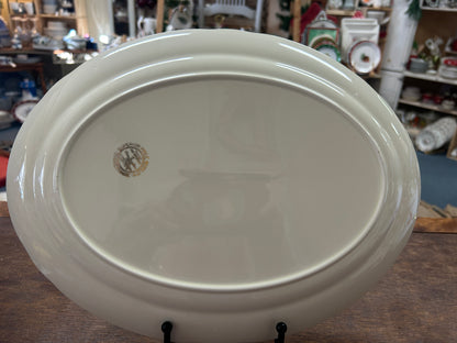 White oval serving platter base with small round maker mark