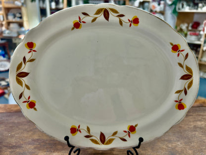 White ceramic autumn leaf platter with multicolor floral rim, scalloped edge
