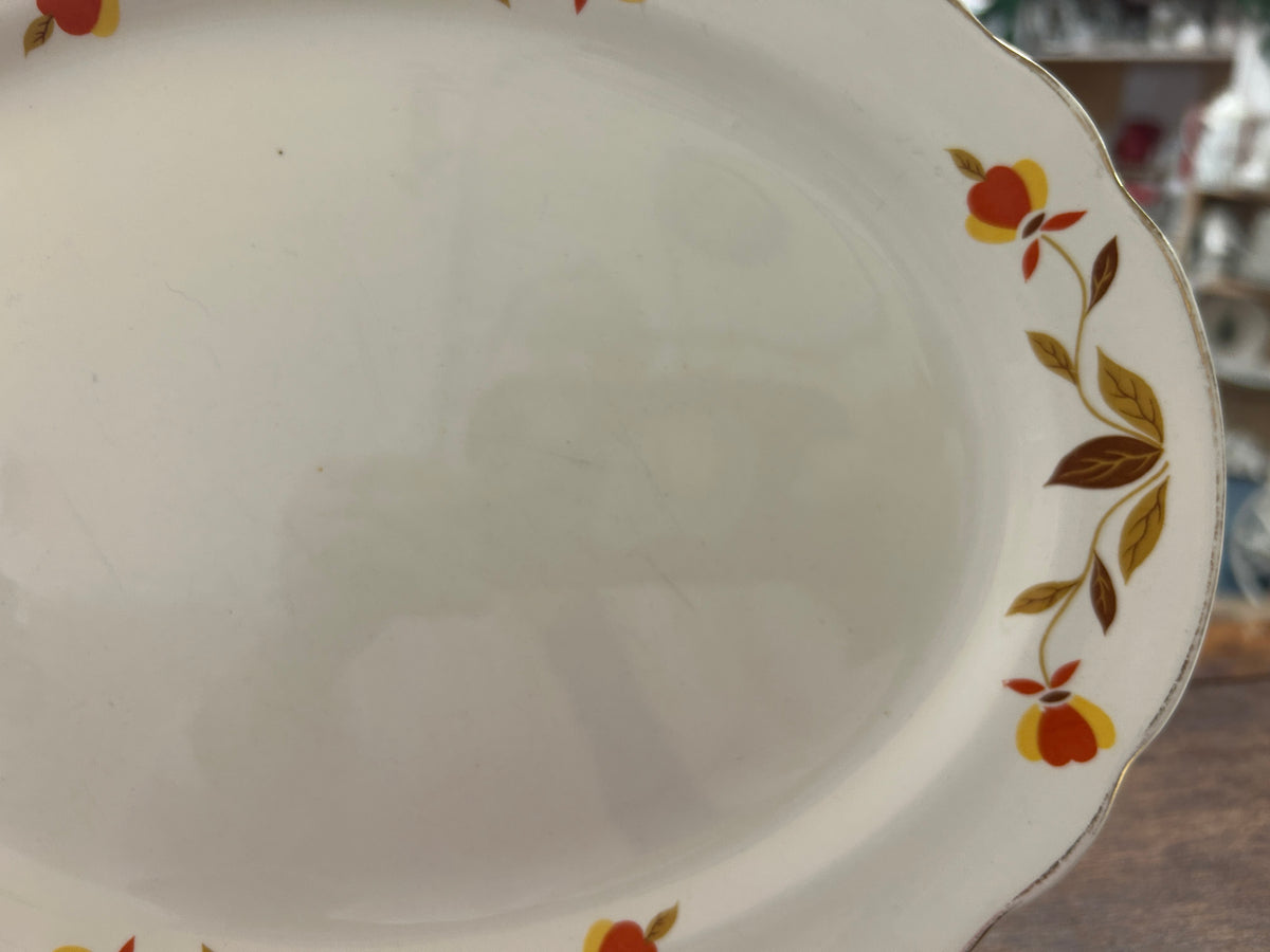 White ceramic platter with multicolor floral border and scalloped edge detail