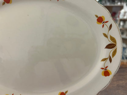White ceramic platter with multicolor floral border and scalloped edge detail