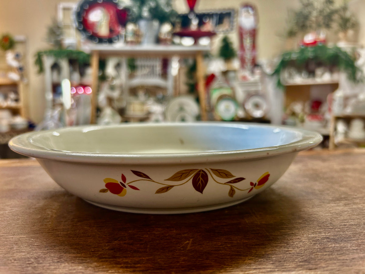 White ceramic pie plate with autumn leaf floral border in red, orange, and brown