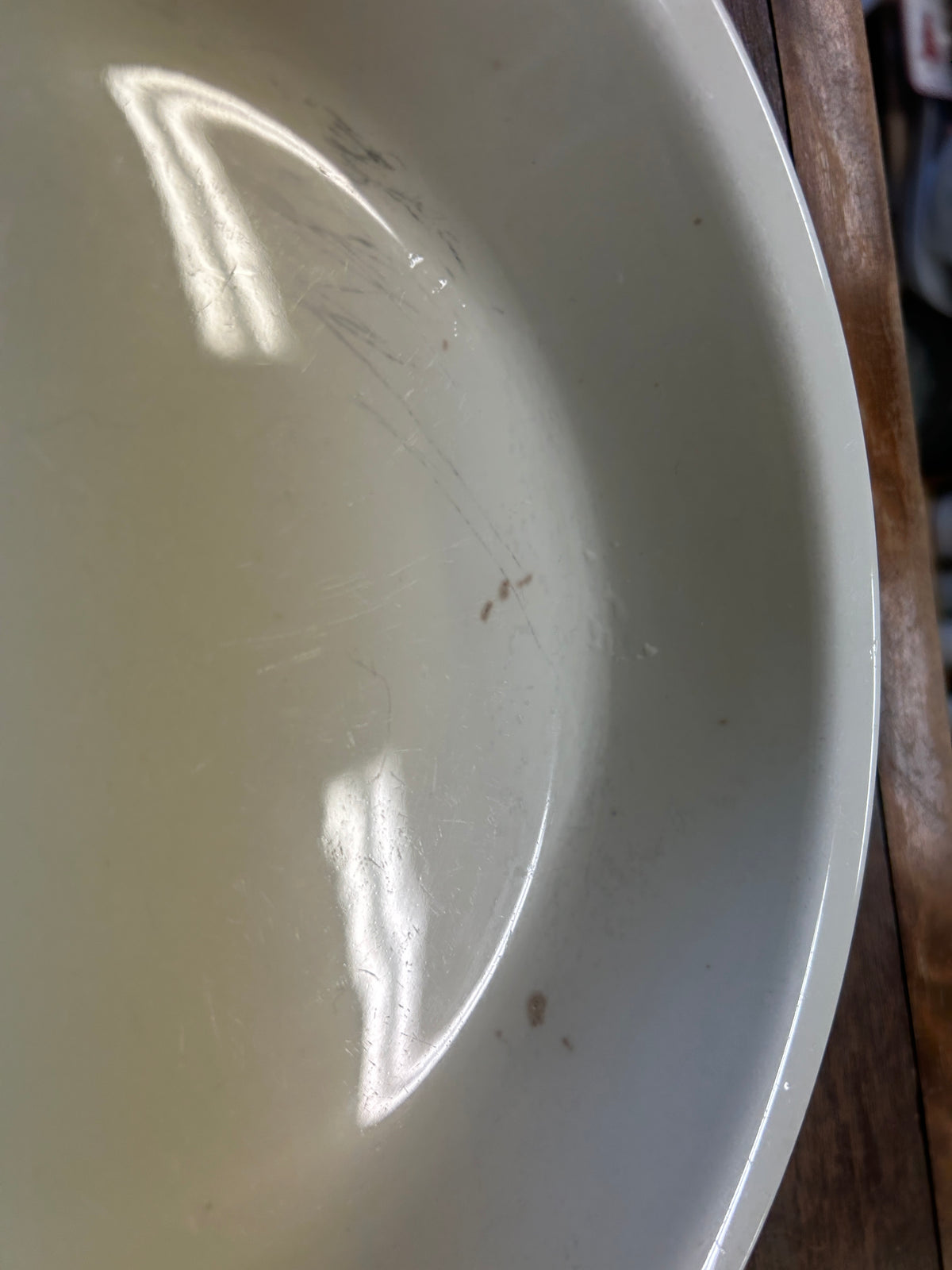 Close-up of white ceramic pie plate interior surface with subtle scratches