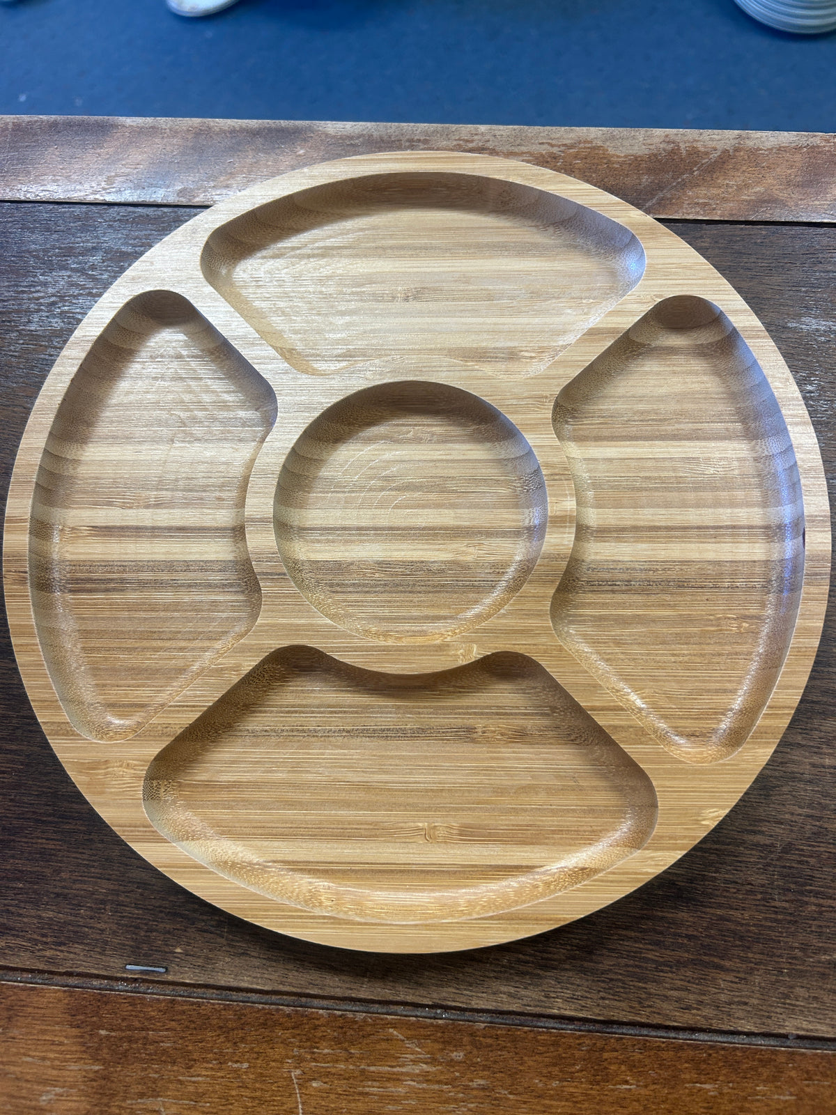 Round five-section wooden serving board with a center well and four surrounding compartments