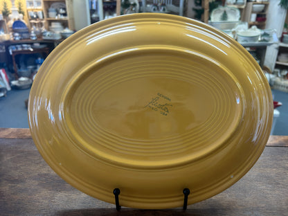 Back of the orange oval platter with raised rings and maker's mark