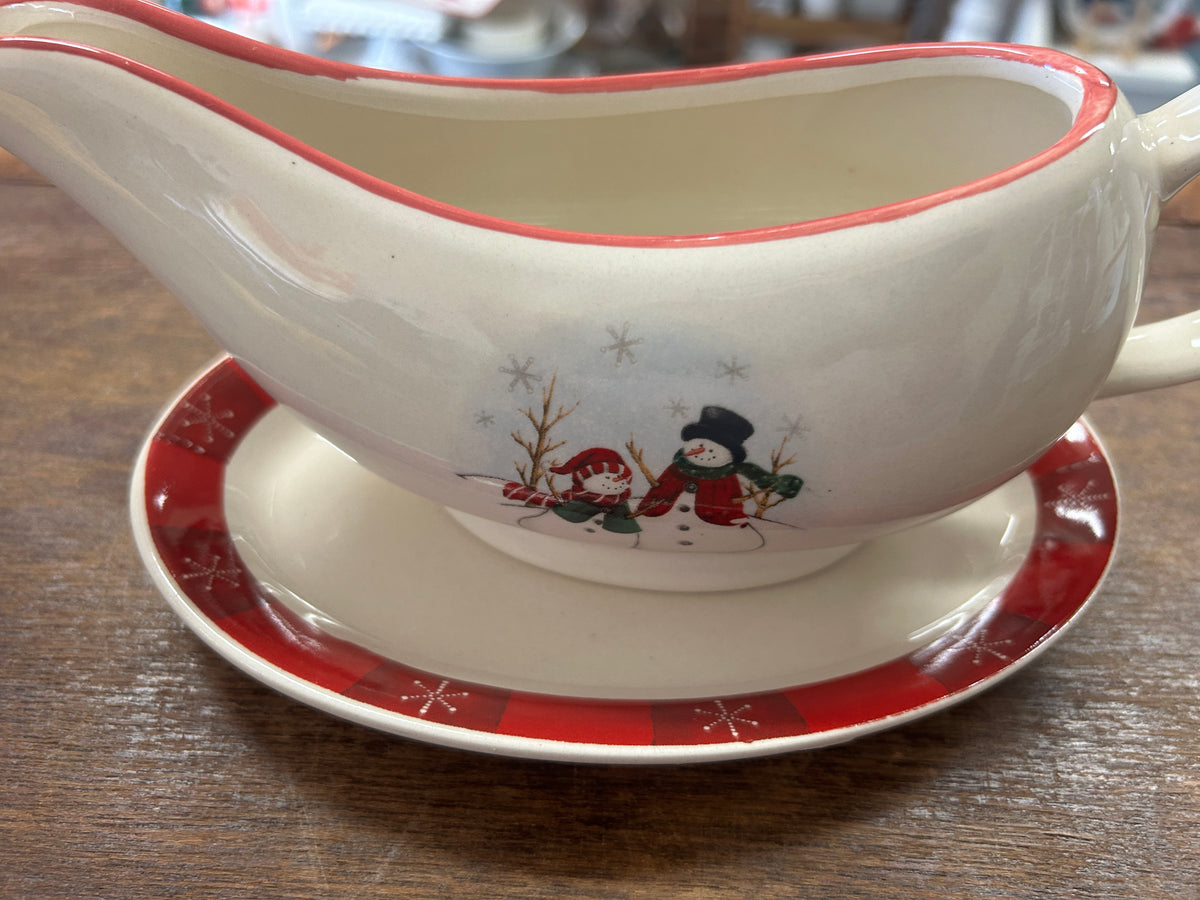 Royal Seasons gravy boat with snowmen, shown on a red snowflake-patterned underplate