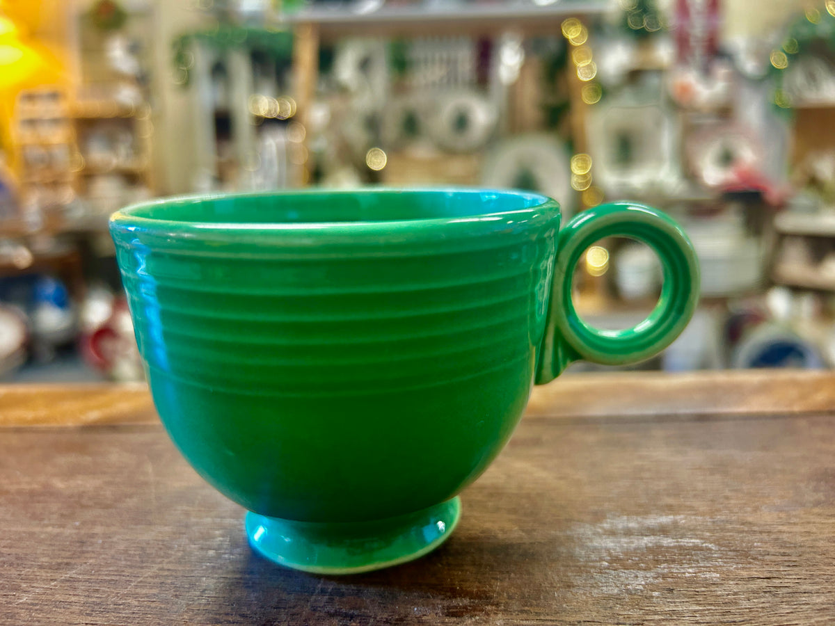 Fiestaware green ceramic cup with ribbed sides, a round keyhole handle and pedestal base