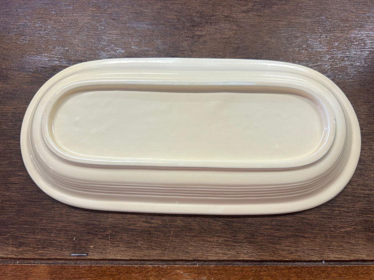 Fiestaware pale yellow platter underside with a raised oval foot and layered ridges