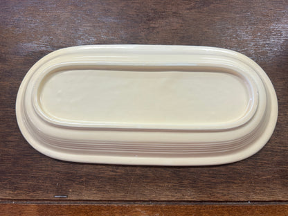 Fiestaware pale yellow platter underside with a raised oval foot and layered ridges