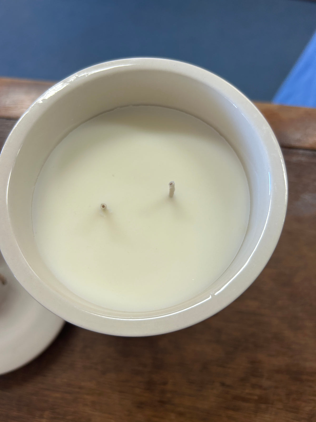Open cream ceramic crock candle filled with pale wax and two wicks