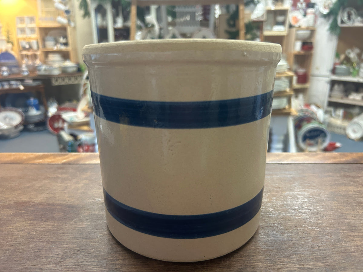 Stoneware crock with cream glaze and two dark blue horizontal stripes.