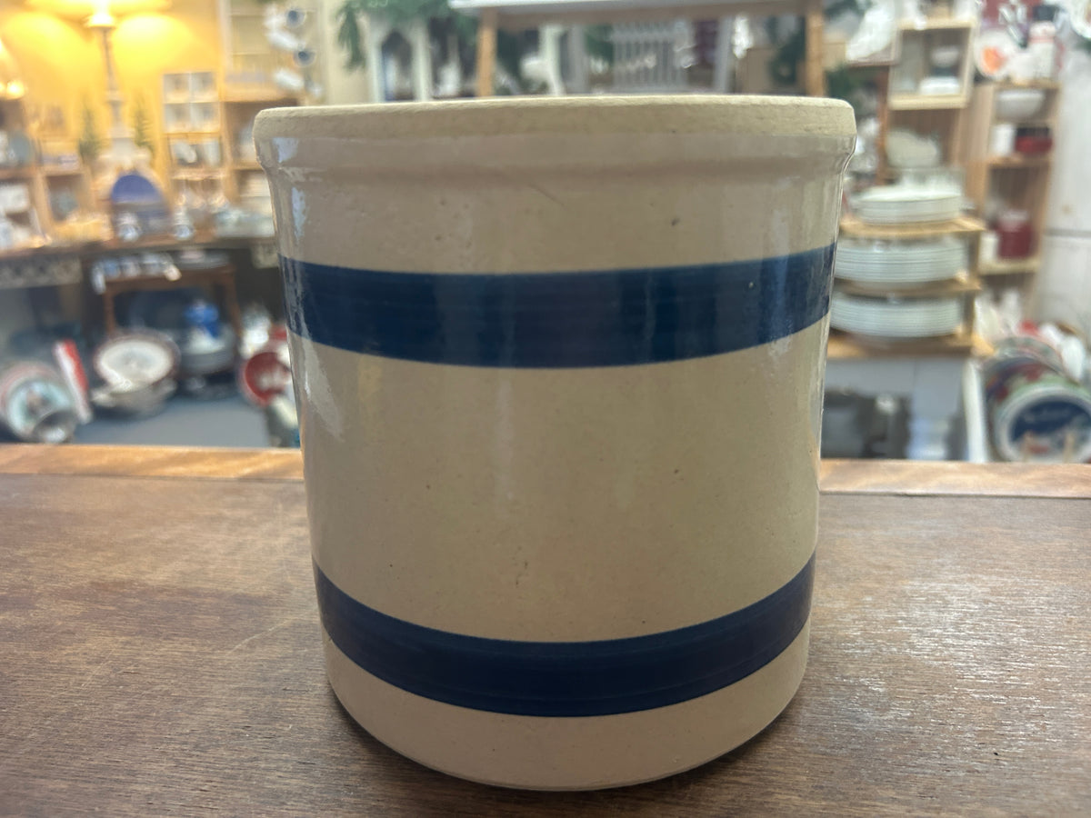 Cream stoneware crock with two dark blue bands and a wide rolled rim.