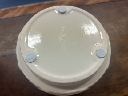 Cream planter pot base with three raised feet.