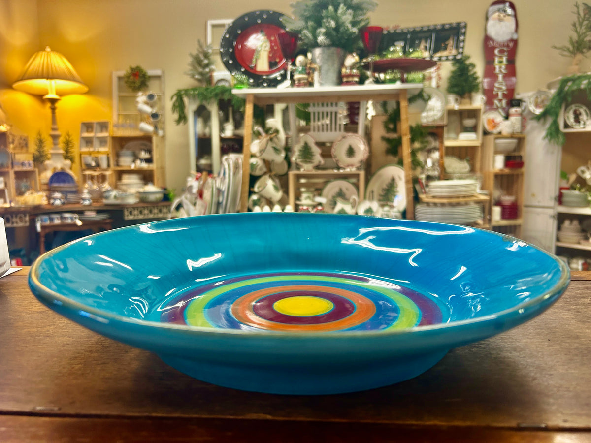 Low-profile blue serving bowl with a colorful concentric pattern in the base