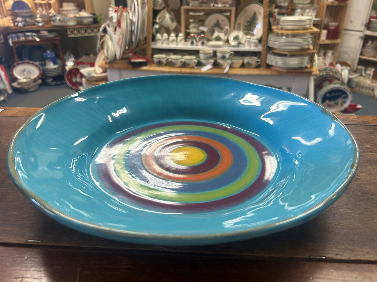 Shallow blue serving bowl with a glossy finish and multicolor rings inside