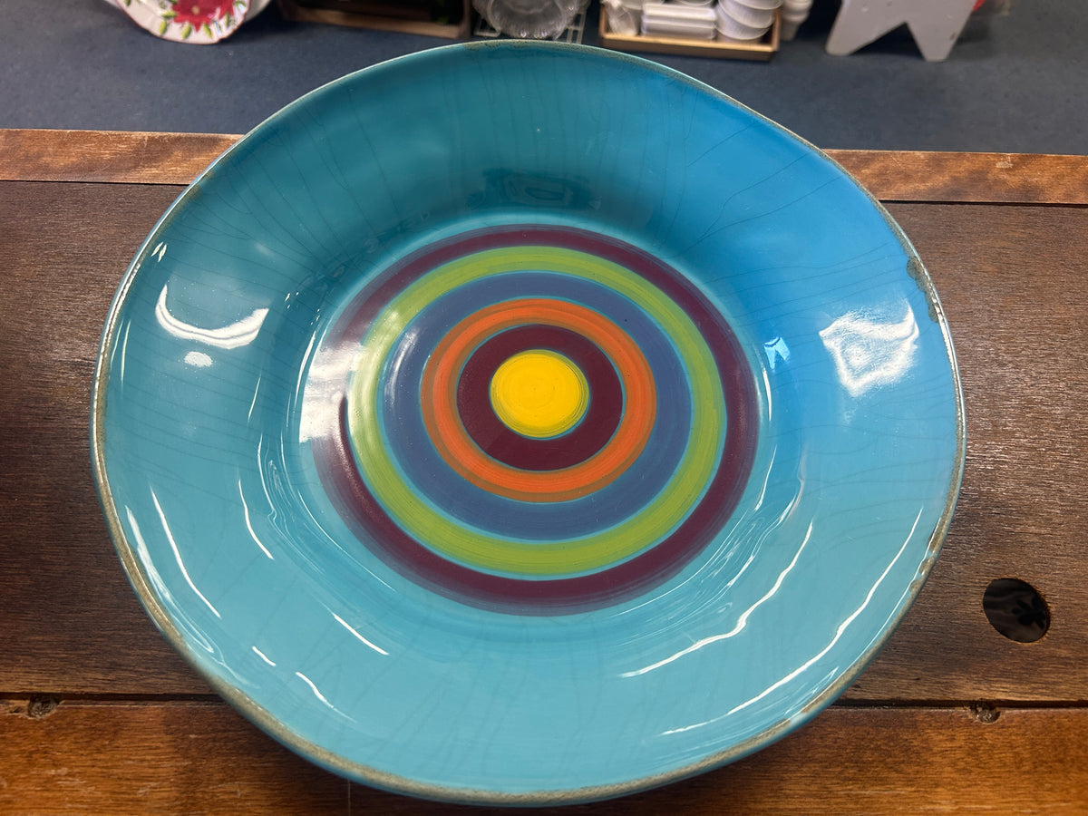 Blue ceramic serving bowl with concentric multicolor rings in the center