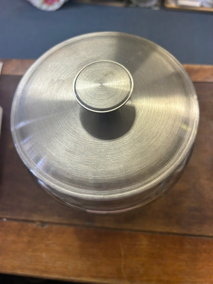 Close-up of the canister's brushed metal lid and central knob