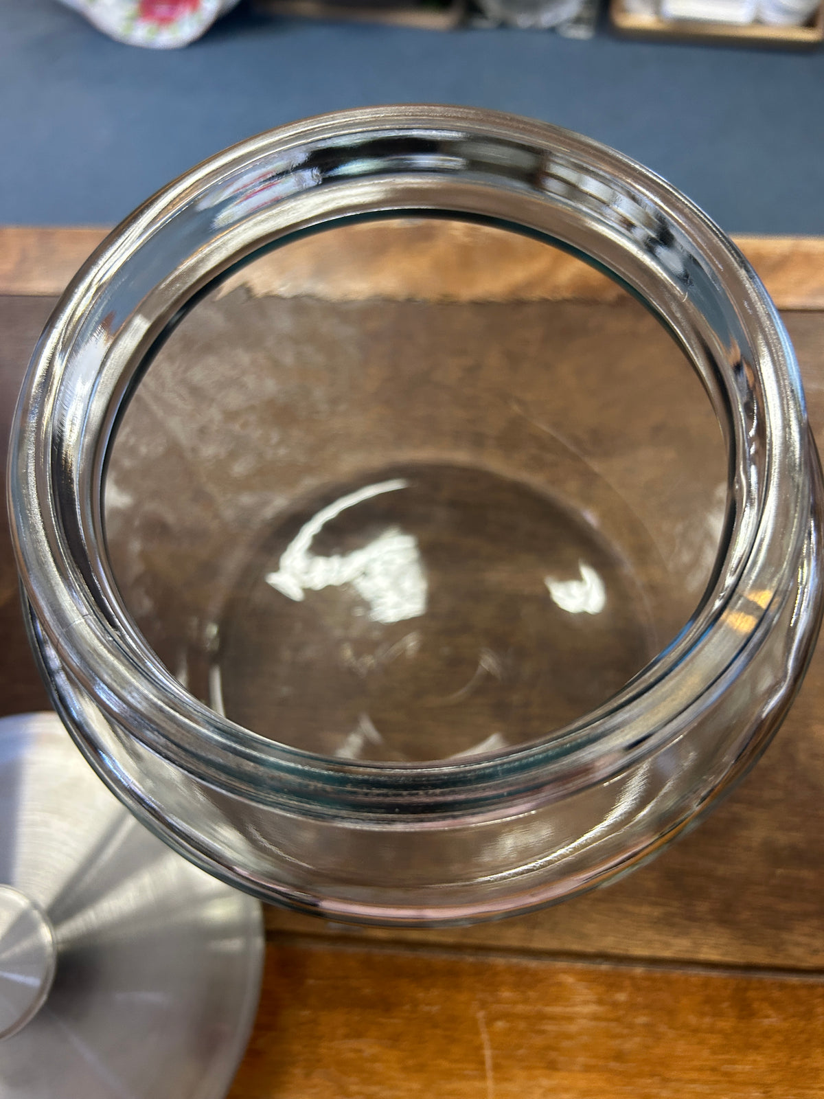 Open clear glass canister showing its wide mouth and removable metal lid