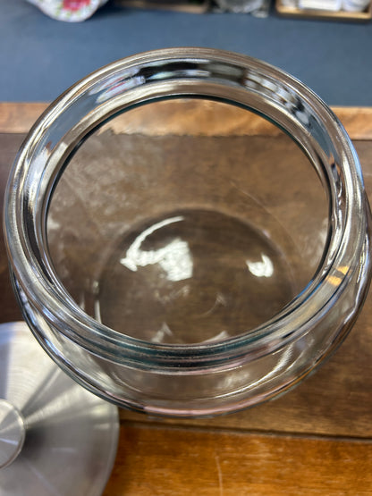 Open clear glass canister showing its wide mouth and removable metal lid