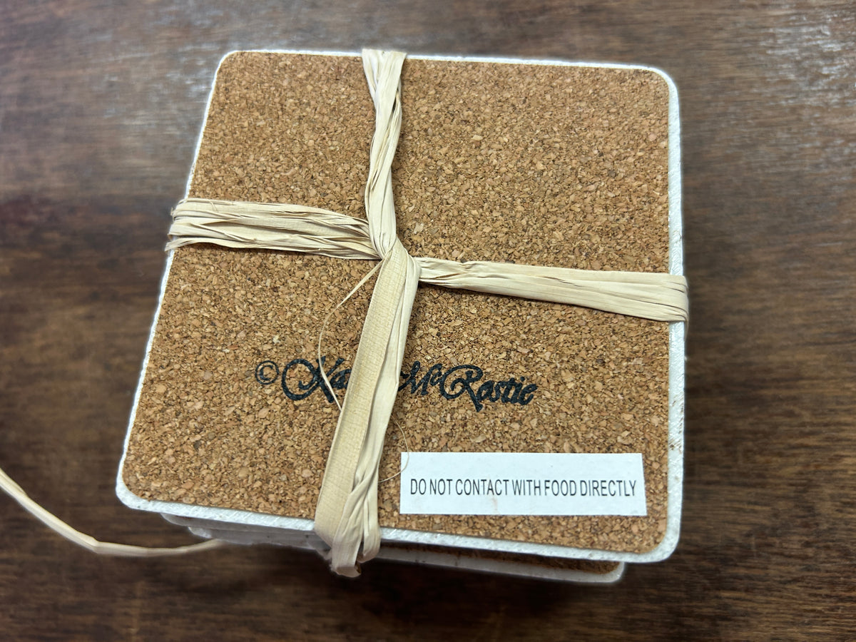 Square coaster underside with cork backing and a food-contact warning label