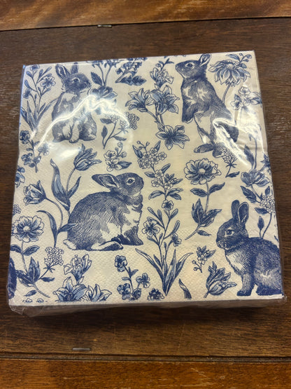Blue and white paper napkins with a repeating rabbit and floral print.
