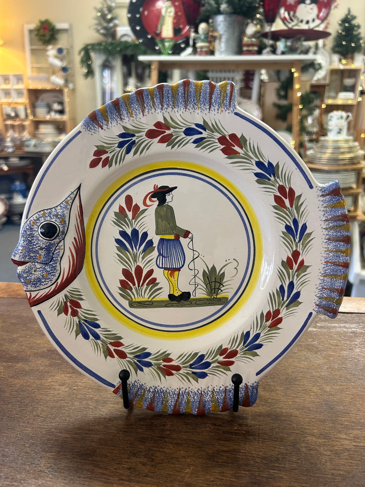 Quimper fish-shaped ceramic plate with colorful floral border and central figure design