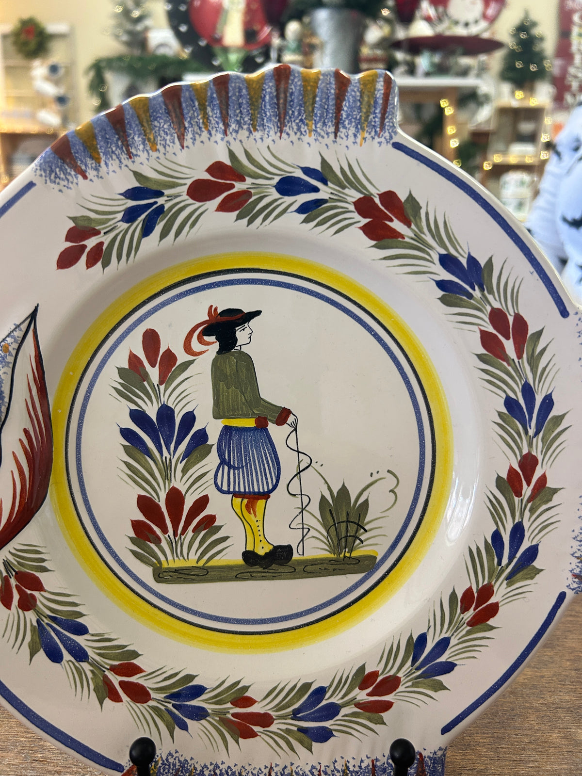 Quimper plate with central figure framed by a colorful floral border