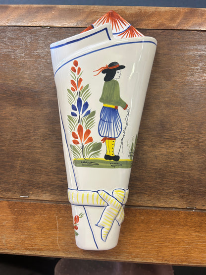 Quimper ceramic wall pocket vase with a painted figure, flowers, and yellow-striped detail