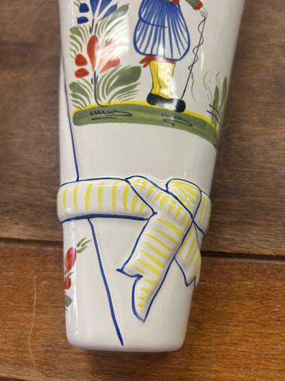 Quimper wall pocket vase detail with yellow-striped painted ribbon and figure's legs