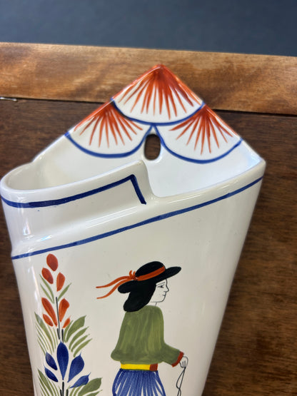 Quimper wall pocket vase with a painted figure and red-striped hanging loop