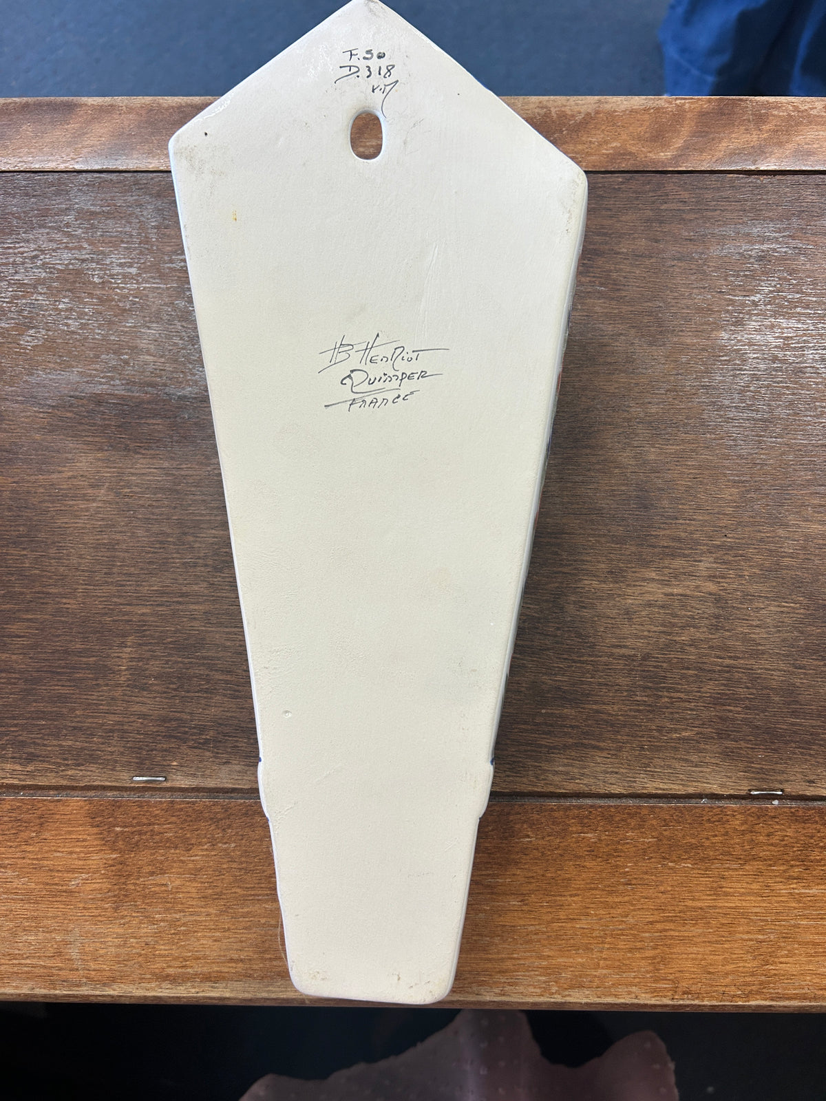 Back of the ceramic wall pocket vase, showing its hanging hole and handwritten marks