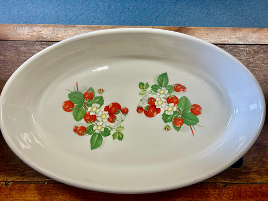 White oval baking dish with red strawberries and green leaf floral pattern