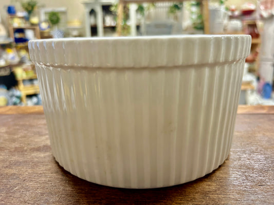White ceramic bowl with vertical fluted sides, scalloped rim