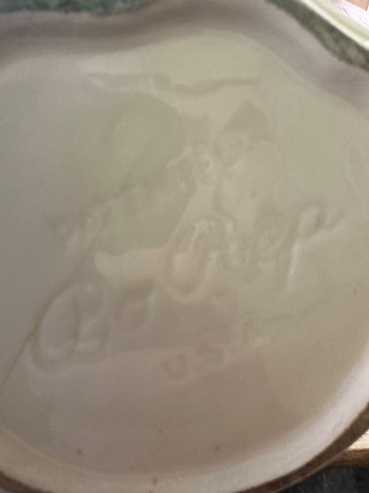 Ceramic pitcher glaze close-up with embossed relief and subtle color staining